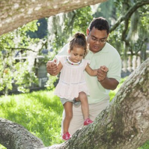 Photo of dad with daughter climbing tree