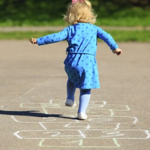 Photo of toddler playing hopscotch